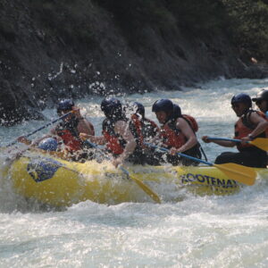 A River Rafting Group paddling through a small rapid of the Toby Creek and getting splashed with Kootenay River Runners