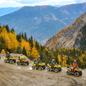 Group of ATV riders on the side of a wet alpine trail near the Paradise Cabin at Toby Creek Adventures