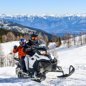 Two riders on a snowmobile tour in Paradise Basin with Toby Creek Adventures.