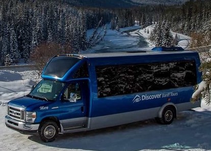 Discover Banff Tour bus in front of a beautiful mountain creek