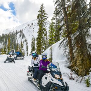 Two people on a snowmobile on a tour with Toby Creek Adventures