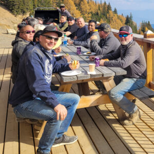 A group of men enjoying a BBQ on the Paradise Cabin deck